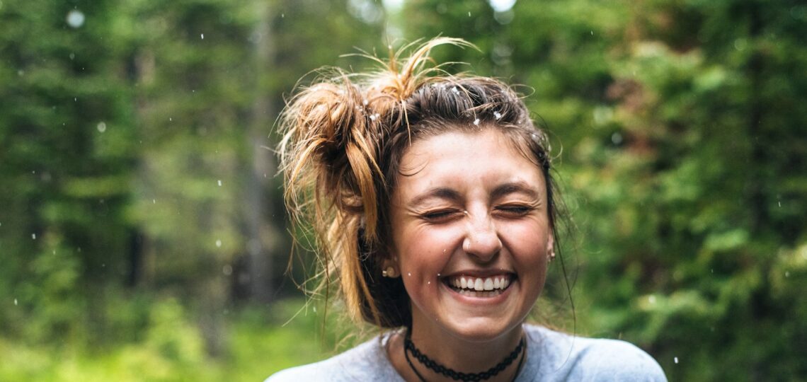 woman smiling near tree outdoor during daytime
